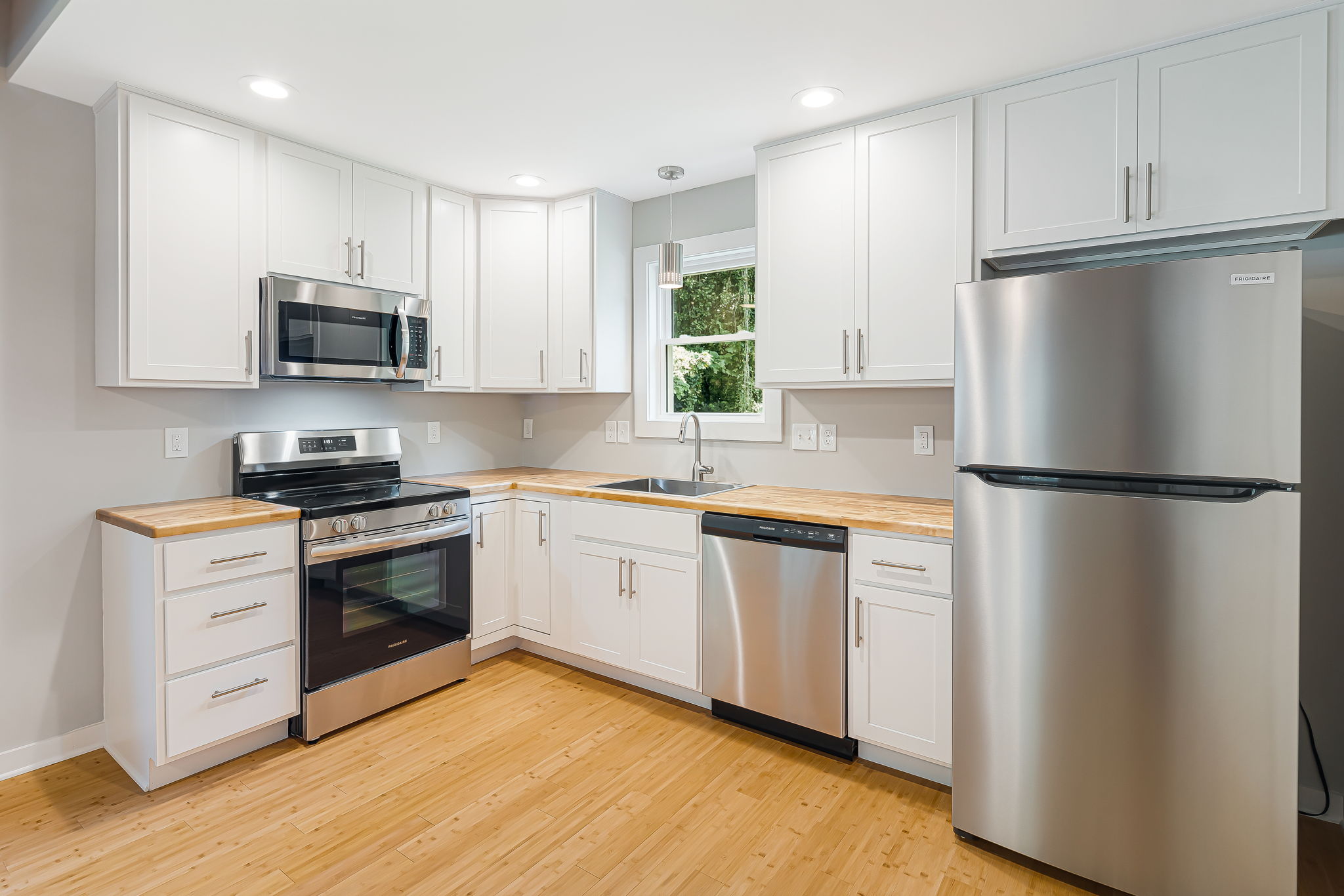 Budget Cottage 2 Bed, kitchen with white cabinets and butcher-block counters